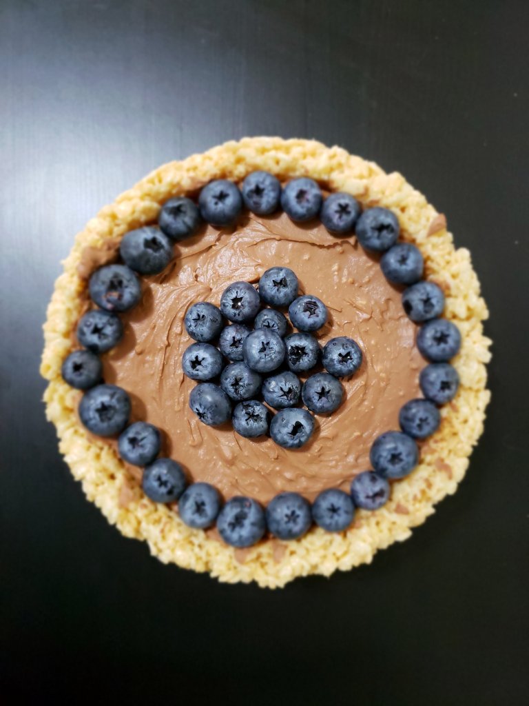 A photo of a No Bake Chocolate Cheesecake, crust made with Rice Krispies, topped with Fresh Blueberries.