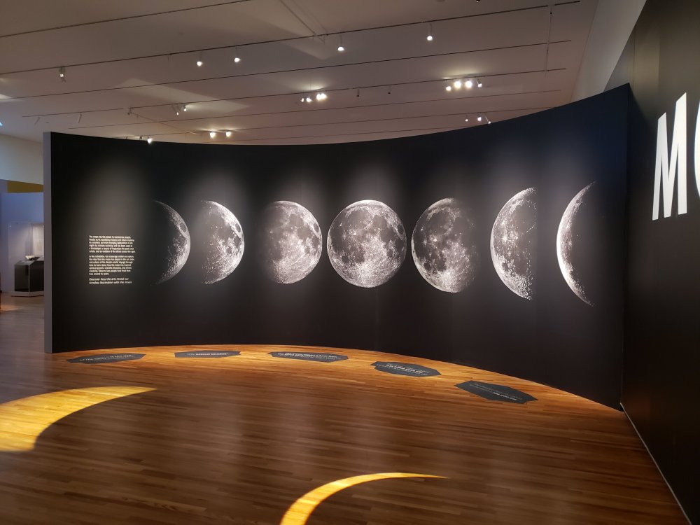 A photo of the entrance to the Moon Exhibit at Aga Khan Museum depecting the phases of the moon.